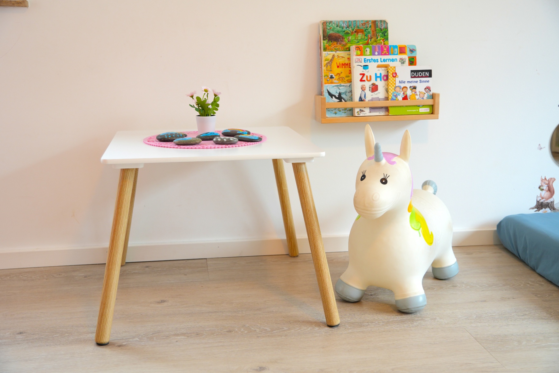 Kindertisch mit Hüpf-Einhorn und Bilderbüchern